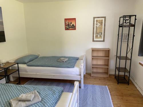 ein Zimmer mit zwei Betten und einem Regal in der Unterkunft Petit in Hatten
