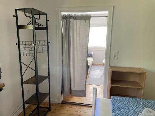 ein Zimmer mit einem Bücherregal neben einer Tür in der Unterkunft Petit in Hatten