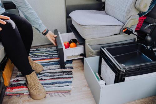 a person sitting on the floor of an rv with a box at Camper Hipalán in San Sebastián de la Gomera