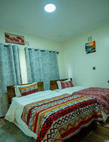 a bedroom with two beds and a window at Naisula Home in Naivasha