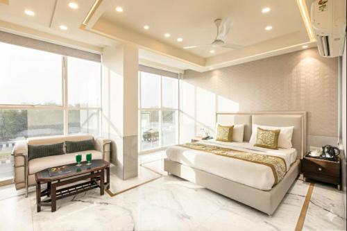 a bedroom with a bed and a couch and a table at Hotel Aero Star by Star Group in New Delhi