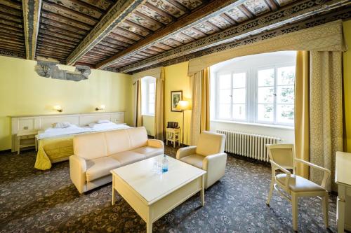 a hotel room with a bed and a couch and a table at Hotel Metamorphis in Prague