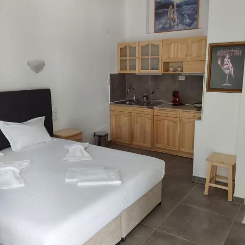 a bedroom with a white bed and a kitchen at ANNA MARIA Studios in Potos