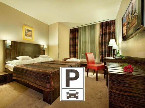 a hotel room with a large bed and a red chair at EA Hotel Crystal Palace in Prague