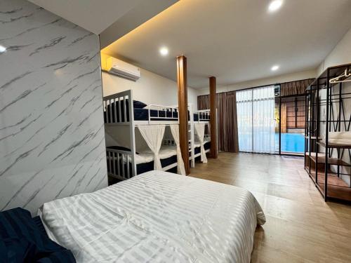 a bedroom with a bed and two bunk beds at Honey Bliss Pool Villa in Hat Yai