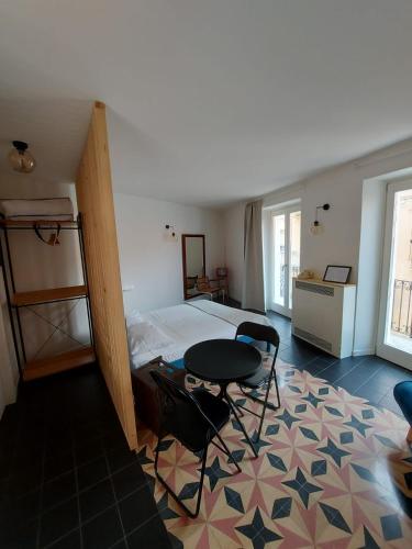 a bedroom with a bed and a table in it at Casa Morenica - Cementina in Montalto Dora
