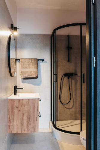 a bathroom with a glass shower and a sink at Hostel Kamienica 9 in Sosnowiec