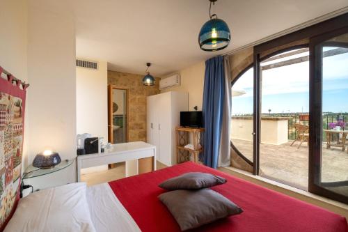 a bedroom with a bed and a large window at Residenze Uliveto - Rooms in Nardò
