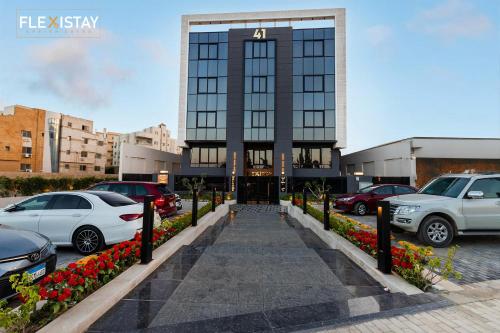 a parking lot with cars parked in front of a building at Flexistay Sheikh Zayed in Sheikh Zayed