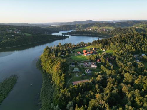 an aerial view of a village on the shore of a river at Apartamenty Wilcza Knieja in Zawóz