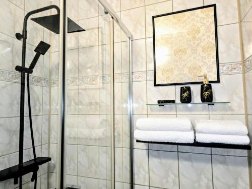 a bathroom with a glass shower stall with towels at Cieszyński by Imperis Hotels in Cieszyn