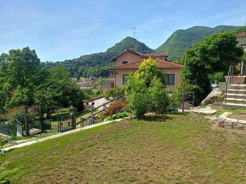 a house with mountains in the background at Casa Silvia Natura Relax, Sport & Family in Omegna
