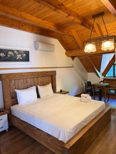 a bedroom with a large bed in a room with wooden ceilings at Hotel - Resort Vellezerit Doka in Klos