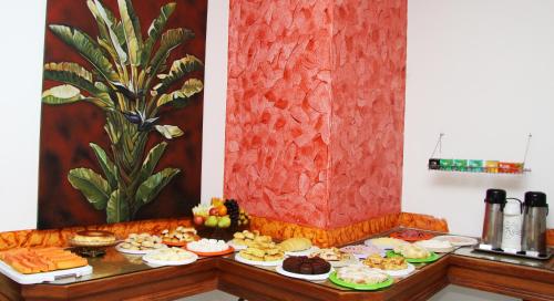 a table filled with different types of food at Cazuza Palace Hotel in Tupã