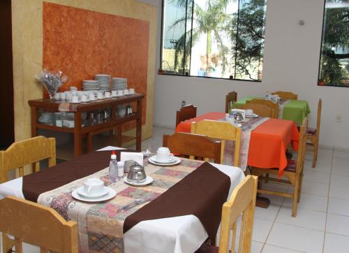a dining room with two tables and chairs at Cazuza Palace Hotel in Tupã