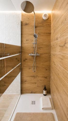 a bathroom with a shower with wooden walls at Studio Cosy in Coussergues