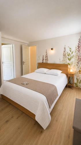 a large bedroom with a large bed with white sheets at Studio Cosy in Coussergues