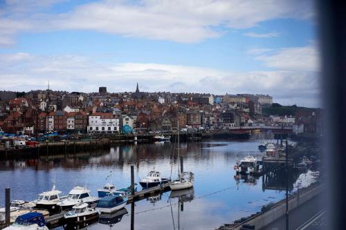 a group of boats docked in a harbor with a city at Host & Stay - Cobblers Cottage in Whitby