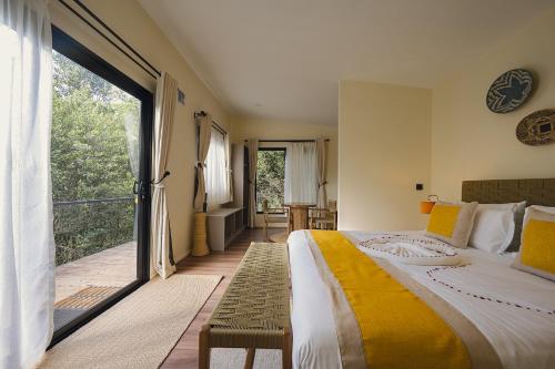 a bedroom with a large bed and a balcony at Pods at Aloe Valley, Ngobit Laikipia in Gatunga