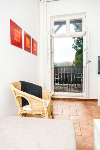 a room with a chair and a window with a balcony at Villa Elise in Bad Schandau
