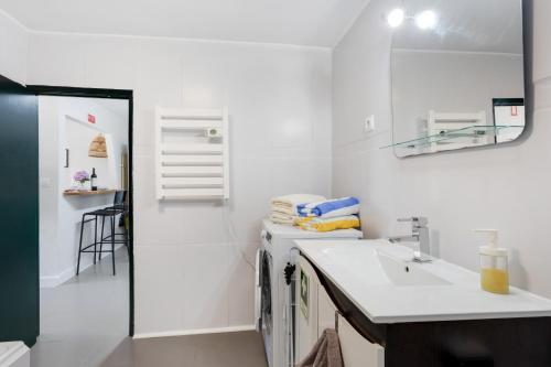 a white bathroom with a sink and a mirror at Casinha Peral Country Cottage in Peral