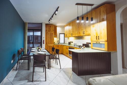 a kitchen with wooden cabinets and a table with chairs at Savoy Signature Stays in Il-Gżira