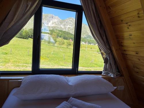a bedroom with a window with a view of a field at Maple Valley in Žabljak