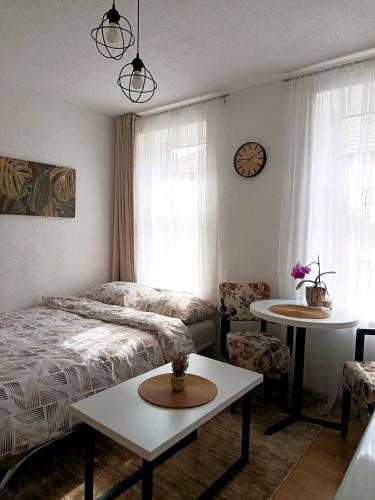 a bedroom with a bed and a table and a clock at Travnik Memories Apartments in Travnik