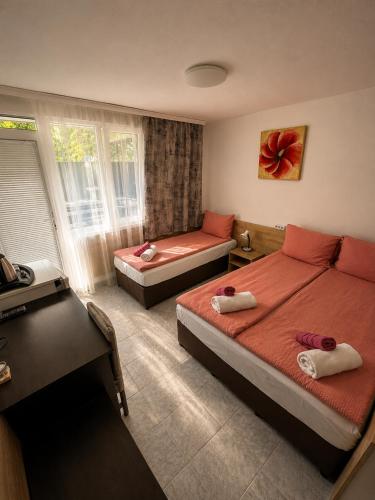 a bedroom with two beds and a window at Family Hotel Yulian in Kranevo