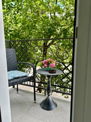 a table with a vase of flowers on a balcony at Апартаменти La Storia in Kamianets-Podilskyi