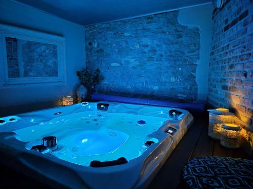 a jacuzzi tub in a room with blue lighting at Cocoon Hébergement Wellness in Chimay