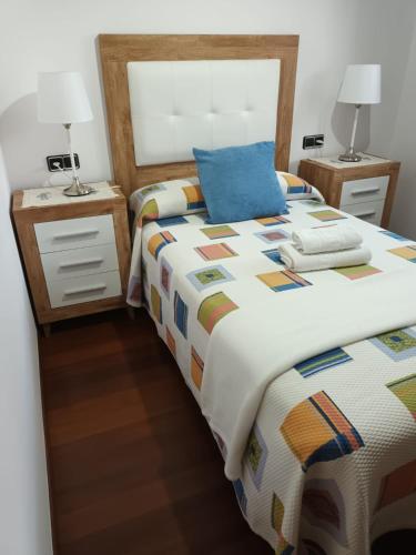 a bedroom with a large bed with a blue pillow at Casa Belarmina in Cangas de Onís