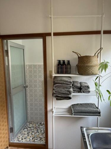 a bathroom with a shower and a rack with towels at Hirakata house, Easy Access to Kyoto and Osaka in Hirakata