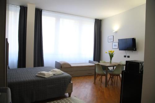 a hotel room with a bed and a table and a television at La Torretta in Savona