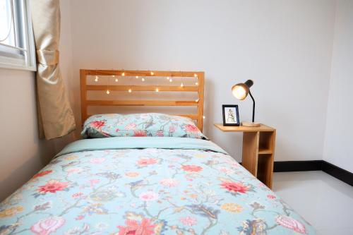 a bedroom with a bed with a floral bedspread at Walking distance Thunder Dome in Ban Bang Phang
