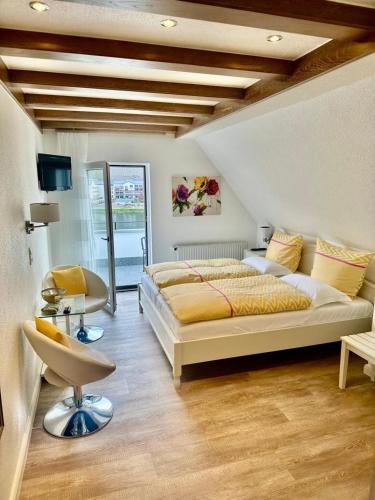 a bedroom with a large bed and a chair at Haus Marientaler Au GbR in Zell an der Mosel
