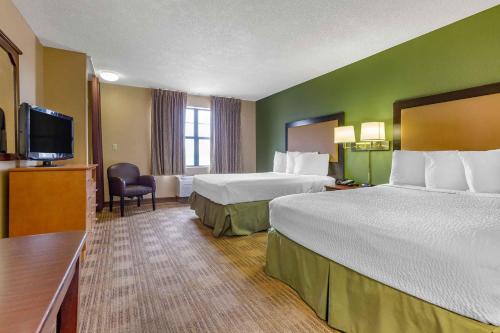 a hotel room with two beds and a flat screen tv at Extended Stay America Select Suites - Phoenix - Deer Valley in Phoenix
