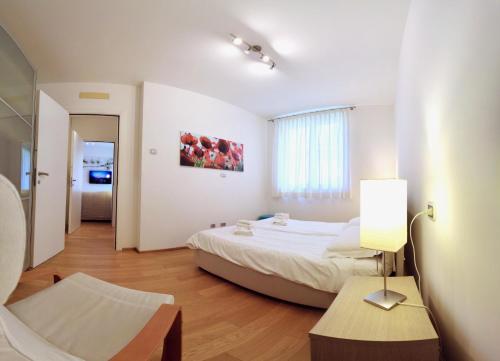 a bedroom with a bed and a table with a lamp at Golfo Gabella Lake Apartments in Maccagno Superiore