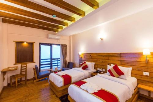 a hotel room with two beds and a desk at DANFÉ Lodge Halesi in Lamidanda