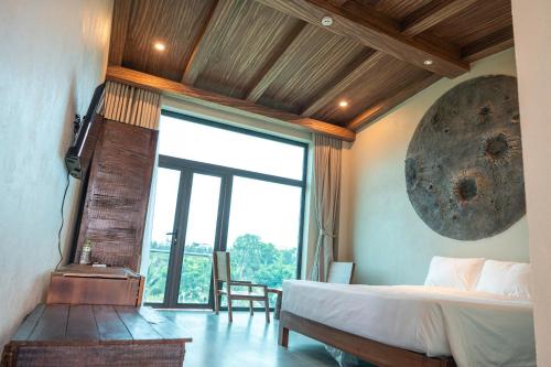 a bedroom with a bed and a large window at Lăng Cô Plaza in Thôn An Hảo
