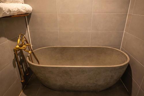 a bath tub in a bathroom with a tiled wall at Lăng Cô Plaza in Thôn An Hảo