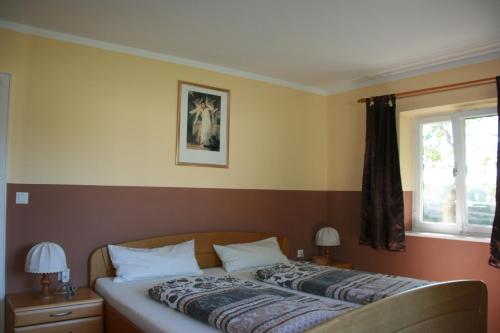 a bed in a bedroom with two lamps and a window at Ferienwohnung Ulrike in Steingaden