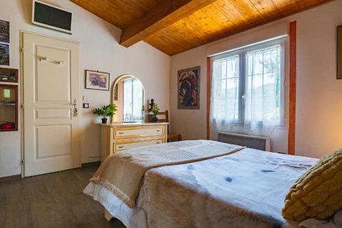 a bedroom with a large bed and a window at Les Issignols - Chambre d'hotes in Colombier-le-Vieux