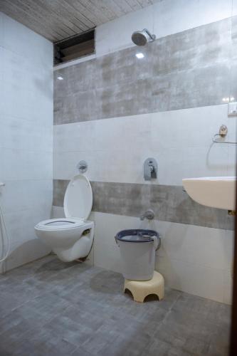 a bathroom with a toilet and a sink at StayGuru Park View Residency in Bhuj