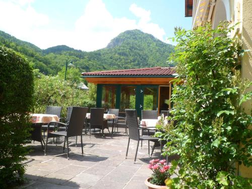 a patio with chairs and tables with mountains in the background at Pension Grünauhof in Grünau im Almtal