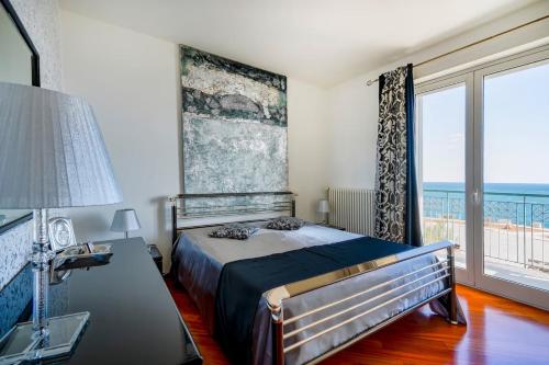 a bedroom with a bed and a large window at Mareincasa Dimora Luxury in Polignano a Mare