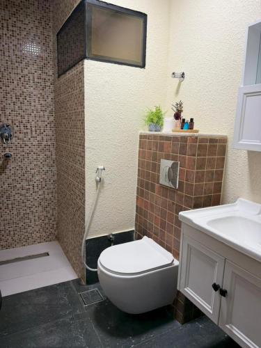 a bathroom with a toilet and a shower and a sink at Zahret Al Roman in Sayq