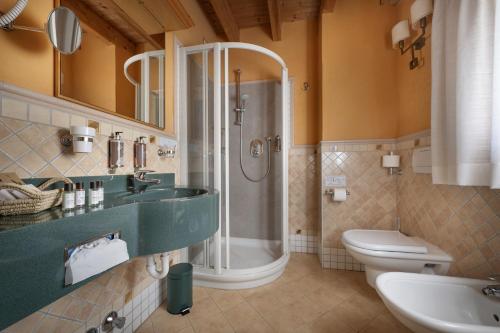 a bathroom with a shower and a sink and a toilet at Bio Hotel Villa Cecilia in Livigno