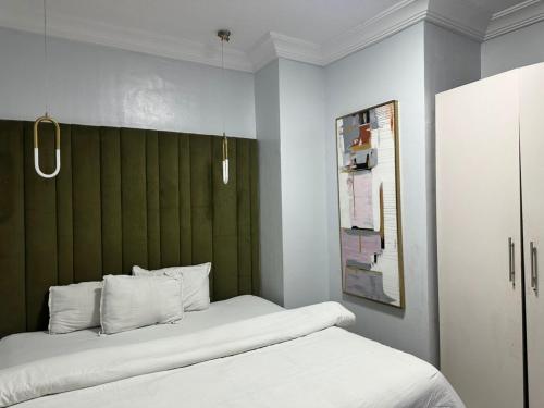 a bedroom with a bed with a green headboard at Luimora Stays in Bamgbose