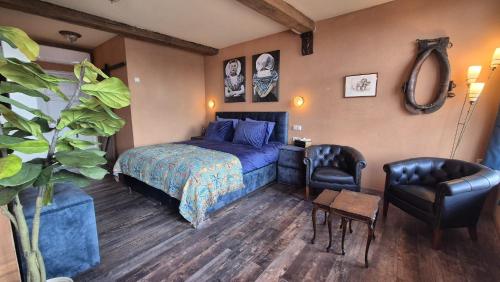a bedroom with a blue bed and a chair at De Gouden Cruytbusse in Middelburg